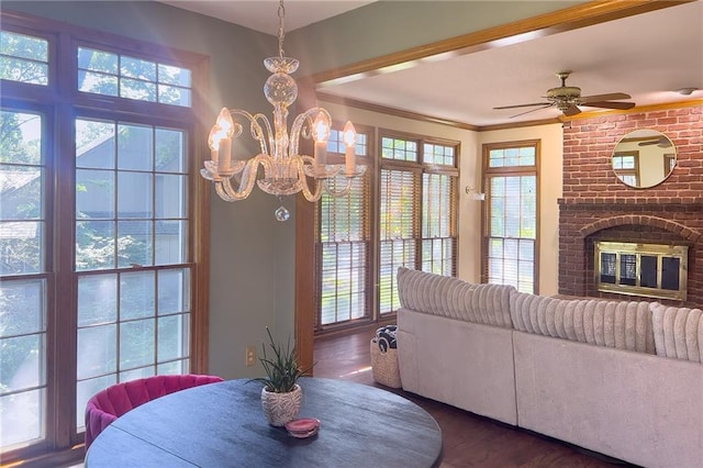 13009 Fontana St, Leawood, KS 66209 - dining area featuring wood finished floors, a chandelier, a fireplace, ceiling fan, and crown molding