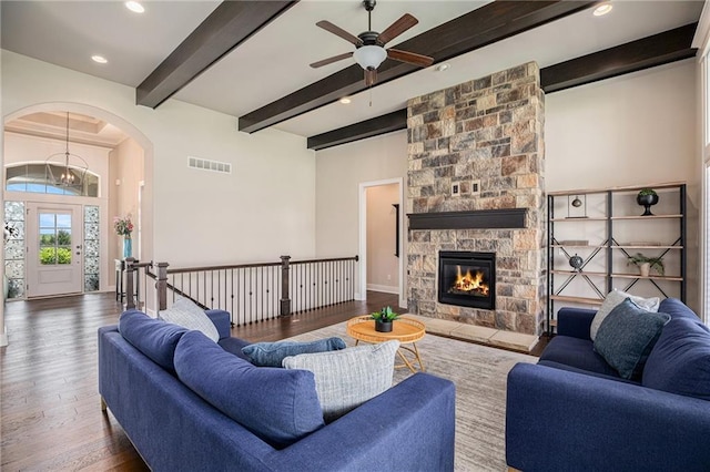 25072 W 114th Ct, Olathe, KS 66061 - living area with beamed ceiling, wood finished floors, arched walkways, ceiling fan, and a fireplace