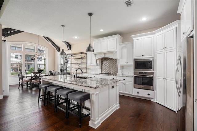 25072 W 114th Ct, Olathe, KS 66061 - kitchen with stainless steel appliances, tasteful backsplash, white cabinets, light stone countertops, and a kitchen island with sink