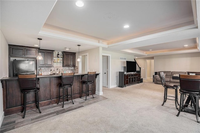 25072 W 114th Ct, Olathe, KS 66061 - kitchen with a raised ceiling, light carpet, a breakfast bar area, dark brown cabinets, and refrigerator