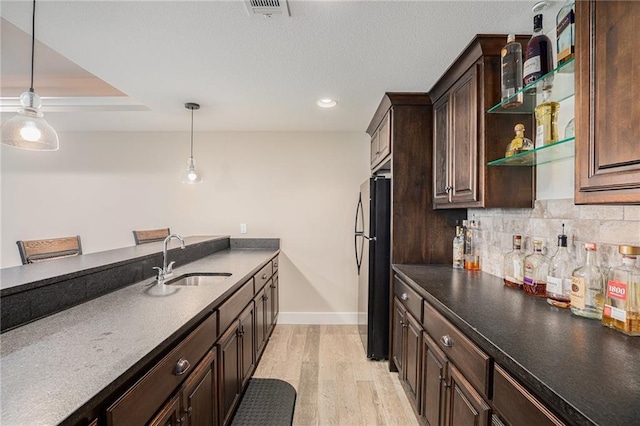 25072 W 114th Ct, Olathe, KS 66061 - kitchen featuring dark brown cabinets, backsplash, light wood-type flooring, freestanding refrigerator, and hanging light fixtures