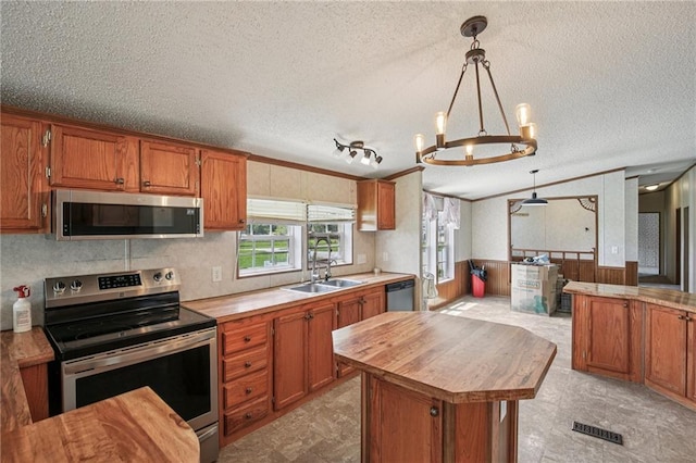 507 NW 165th Rd, Centerview, MO 64019 - kitchen with stainless steel appliances, a textured ceiling, wooden counters, brown cabinetry, and a wainscoted wall