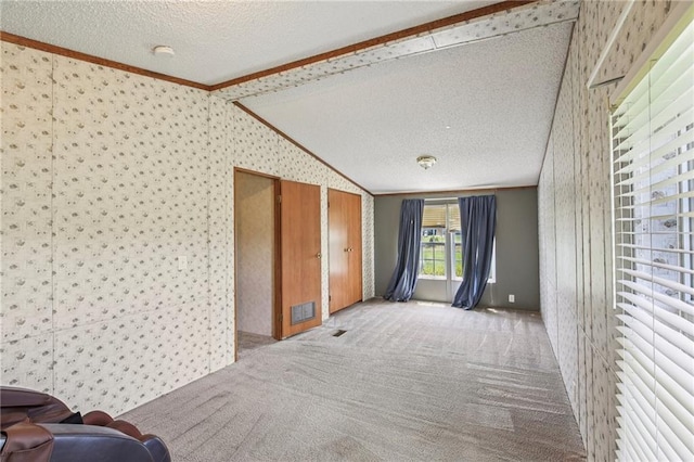 507 NW 165th Rd, Centerview, MO 64019 - unfurnished living room featuring lofted ceiling, carpet floors, a textured ceiling, crown molding, and wallpapered walls