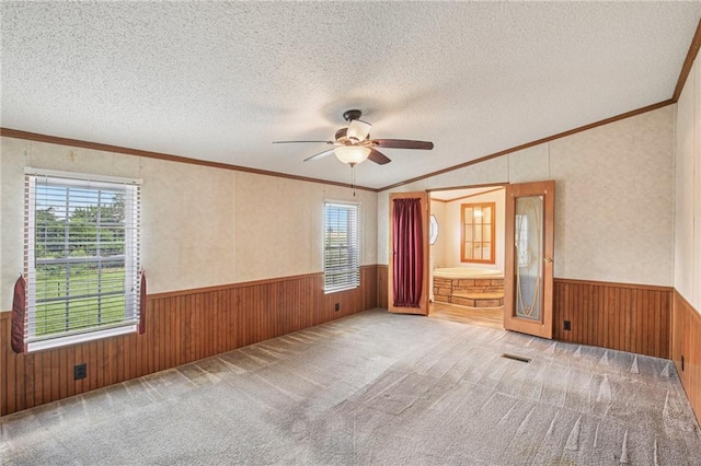 507 NW 165th Rd, Centerview, MO 64019 - carpeted empty room featuring wainscoting, wood walls, healthy amount of natural light, ornamental molding, and a ceiling fan