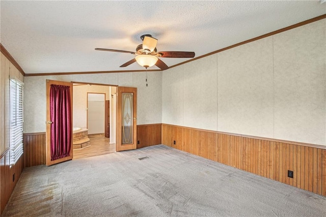 507 NW 165th Rd, Centerview, MO 64019 - empty room with crown molding, wooden walls, a textured ceiling, ceiling fan, and a wainscoted wall