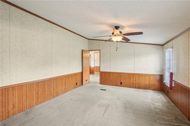 507 NW 165th Rd, Centerview, MO 64019 - carpeted spare room with ceiling fan, wooden walls, crown molding, a wainscoted wall, and a textured ceiling
