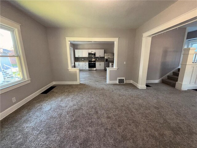 1114 N Liberty St, Independence, MO 64050 - unfurnished living room with carpet flooring and stairway