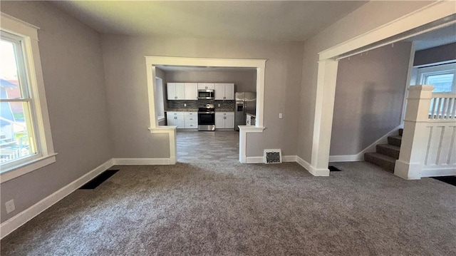 1114 N Liberty St, Independence, MO 64050 - spare room featuring dark colored carpet and stairway