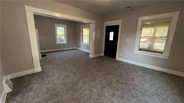 1114 N Liberty St, Independence, MO 64050 - entrance foyer featuring dark colored carpet and baseboards