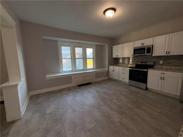 1114 N Liberty St, Independence, MO 64050 - kitchen featuring stainless steel appliances, tasteful backsplash, and white cabinets