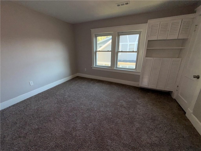 1114 N Liberty St, Independence, MO 64050 - spare room with dark colored carpet and baseboards
