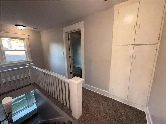 1114 N Liberty St, Independence, MO 64050 - corridor with dark carpet and an upstairs landing