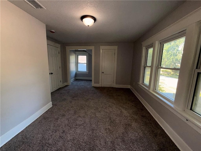 1114 N Liberty St, Independence, MO 64050 - spare room featuring dark carpet and a textured ceiling