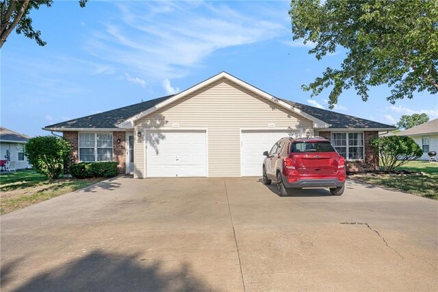 212 NW Parker Dr, Grain Valley, MO 64029 - ranch-style home with a garage, driveway, and brick siding
