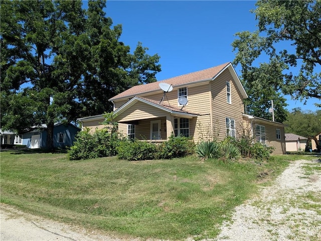 707 N 4th St, La Cygne, KS 66040 - view of side of home with dirt driveway and a lawn