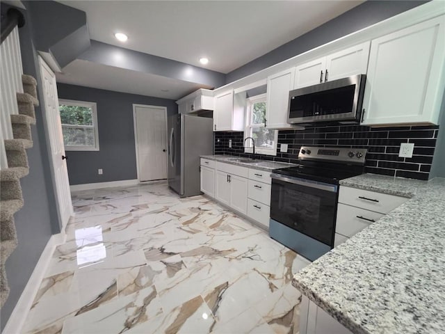 1027 Ohio Ave, Kansas City, KS 66102 - kitchen with appliances with stainless steel finishes, decorative backsplash, white cabinetry, recessed lighting, and healthy amount of natural light