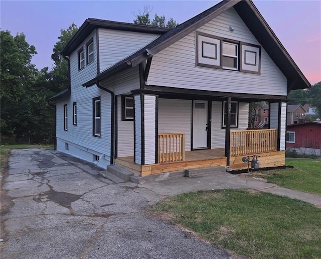 1027 Ohio Ave, Kansas City, KS 66102 - bungalow-style home featuring covered porch, asphalt driveway, and a front yard