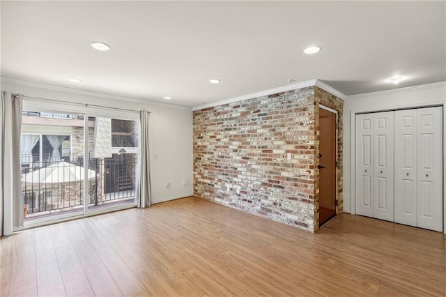5006 Baltimore Ave Unit 205, Kansas City, MO 64112 - unfurnished room featuring crown molding, brick wall, light wood-type flooring, and recessed lighting