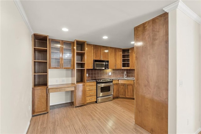 5006 Baltimore Ave Unit 205, Kansas City, MO 64112 - kitchen featuring open shelves, stainless steel appliances, ornamental molding, brown cabinets, and built in desk