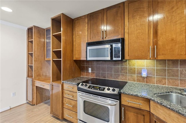 5006 Baltimore Ave Unit 205, Kansas City, MO 64112 - kitchen with stainless steel electric stove, open shelves, crown molding, light wood-style flooring, and dark stone counters