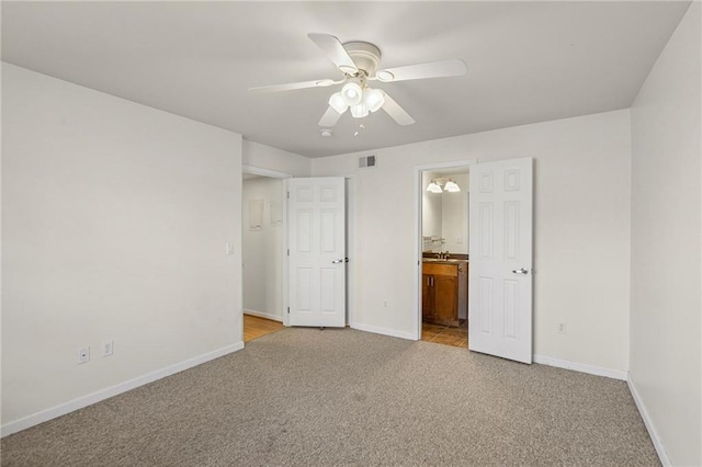 5006 Baltimore Ave Unit 205, Kansas City, MO 64112 - unfurnished bedroom featuring light colored carpet, connected bathroom, and a ceiling fan