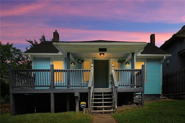 3808 Anderson Ave, Kansas City, MO 64123 - view of front of property with a chimney, a porch, and roof with shingles