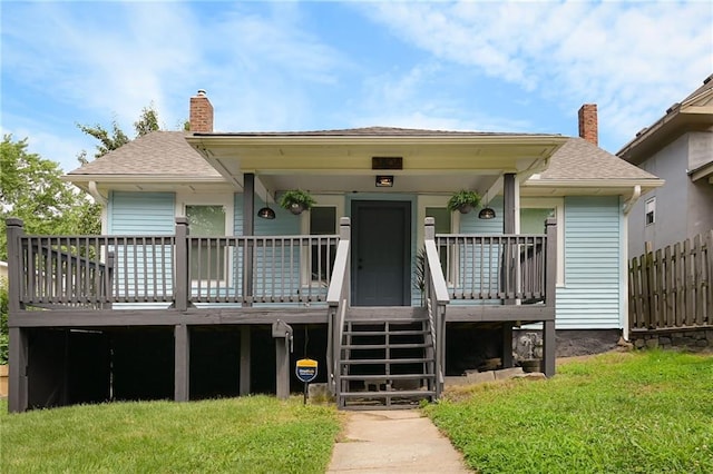 3808 Anderson Ave, Kansas City, MO 64123 - view of front of home featuring a chimney, a shingled roof, and covered porch