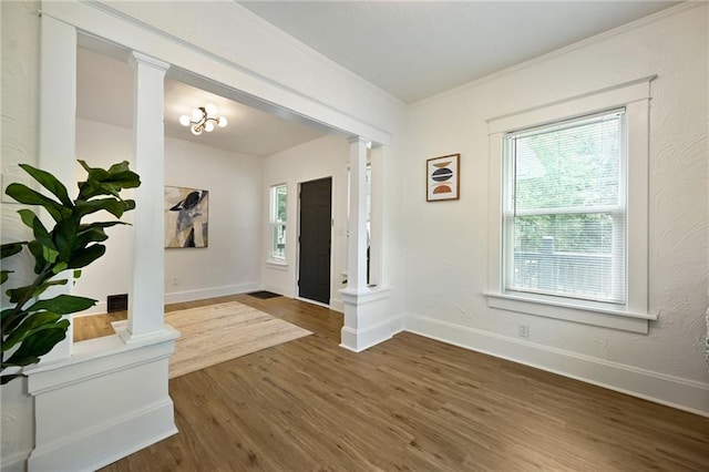3808 Anderson Ave, Kansas City, MO 64123 - entryway with decorative columns, wood finished floors, and ornamental molding