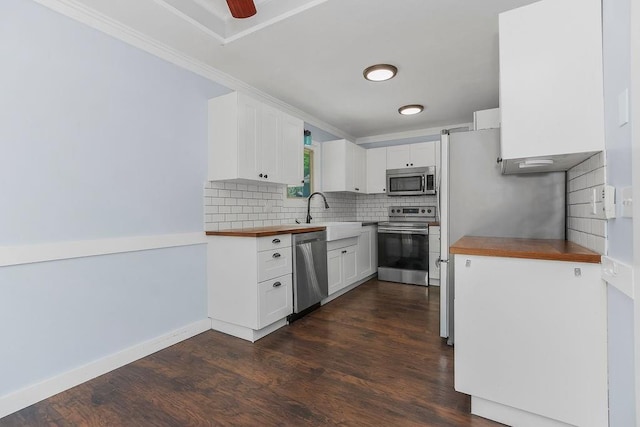 1401 NE Weddle Ln, Lees Summit, MO 64086 - kitchen with appliances with stainless steel finishes, backsplash, dark wood-style floors, white cabinets, and ornamental molding