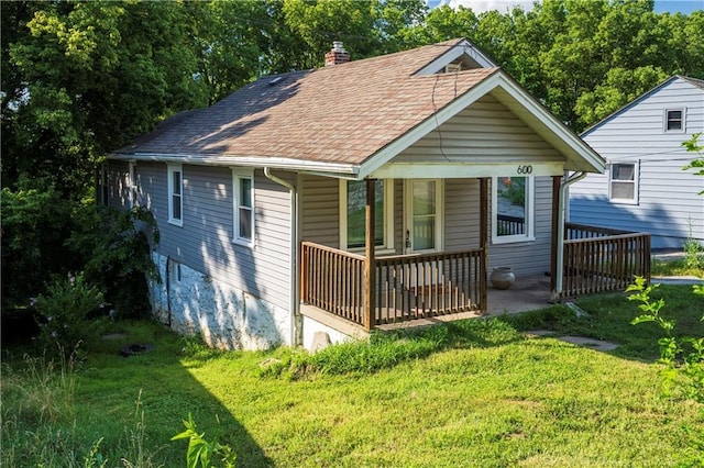 600 Ridgeview Ave, Kansas City, KS 66103 - view of front of home with a shingled roof, a front yard, a chimney, and a porch