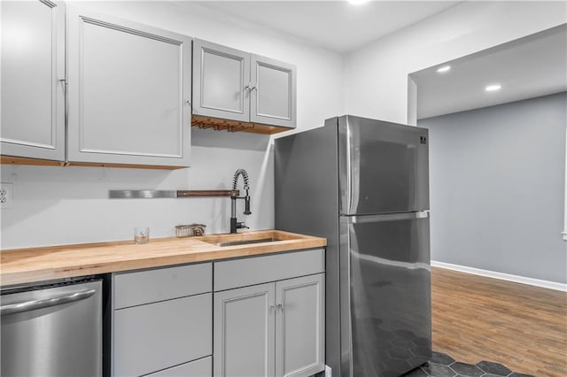 600 Ridgeview Ave, Kansas City, KS 66103 - kitchen featuring stainless steel appliances, wood counters, recessed lighting, dark wood-style flooring, and gray cabinetry