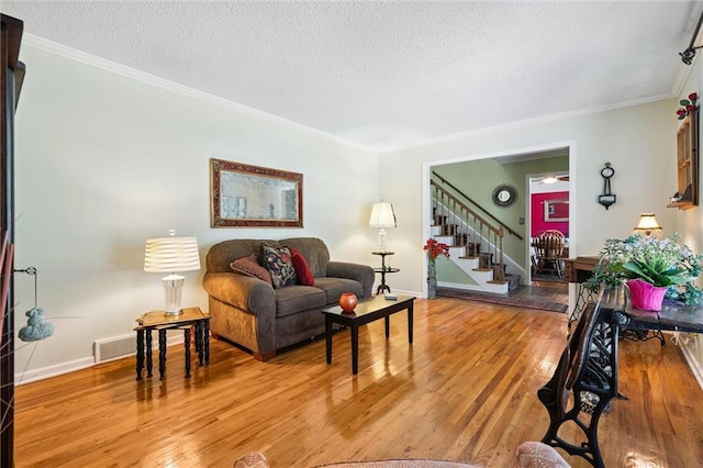 7211 Goodman St, Overland Park, KS 66204 - living room featuring stairs, a textured ceiling, wood finished floors, and ornamental molding