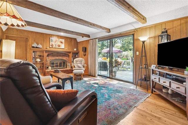 7211 Goodman St, Overland Park, KS 66204 - living area with wood walls, light wood finished floors, a textured ceiling, beamed ceiling, and a fireplace