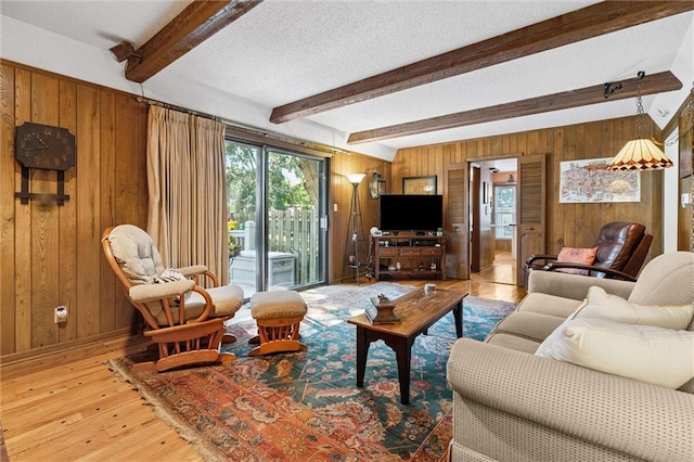 7211 Goodman St, Overland Park, KS 66204 - living room featuring wooden walls, healthy amount of natural light, wood-type flooring, beamed ceiling, and a textured ceiling