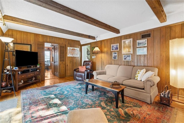7211 Goodman St, Overland Park, KS 66204 - living area with beamed ceiling, wood finished floors, wood walls, and a textured ceiling