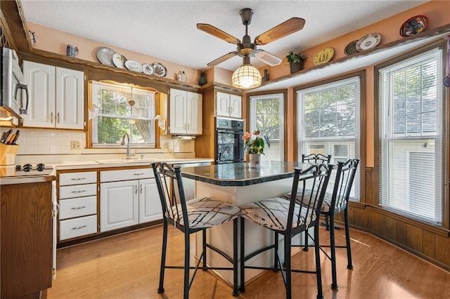 7211 Goodman St, Overland Park, KS 66204 - dining room with light wood-type flooring, a textured ceiling, and ceiling fan