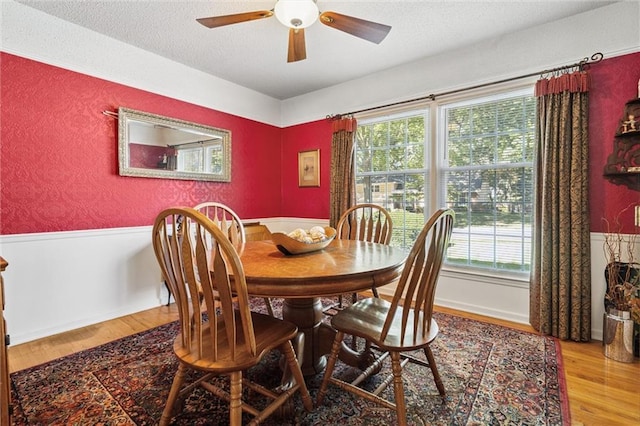 7211 Goodman St, Overland Park, KS 66204 - dining space with healthy amount of natural light, wood finished floors, a ceiling fan, wainscoting, and a textured ceiling