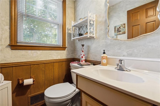 7211 Goodman St, Overland Park, KS 66204 - bathroom with vanity, a wainscoted wall, and wood walls