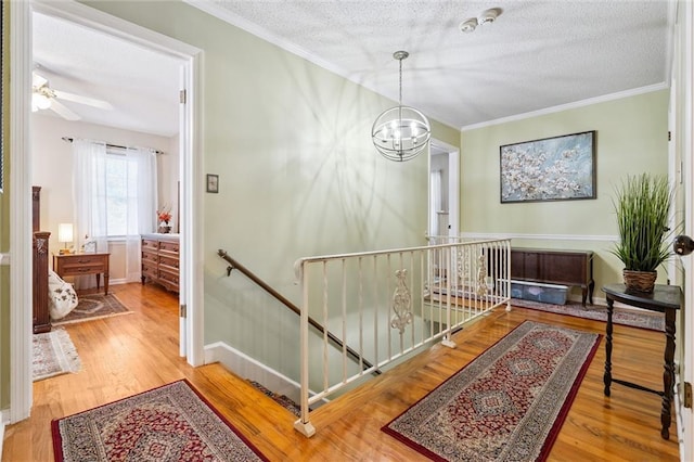7211 Goodman St, Overland Park, KS 66204 - corridor featuring an upstairs landing, a textured ceiling, crown molding, wood finished floors, and a chandelier