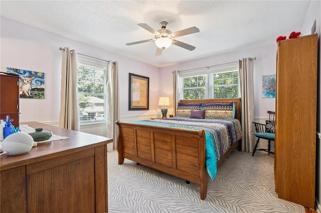 7211 Goodman St, Overland Park, KS 66204 - bedroom featuring multiple windows, a textured ceiling, light carpet, and a ceiling fan