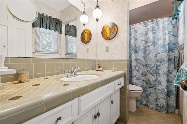 7211 Goodman St, Overland Park, KS 66204 - bathroom with vanity, tile patterned flooring, tile walls, and a shower with curtain