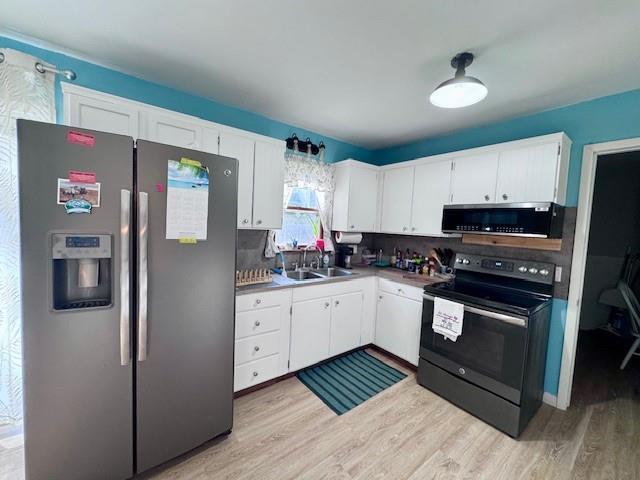 1012 Meadowbrook Rd E, Iola, KS 66749 - kitchen featuring stainless steel appliances, light wood-style flooring, and white cabinetry