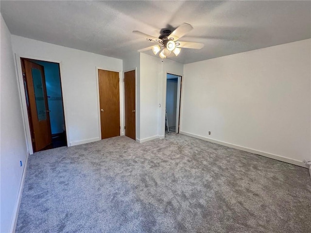 1012 Meadowbrook Rd E, Iola, KS 66749 - unfurnished bedroom with carpet, ceiling fan, two closets, and a textured ceiling