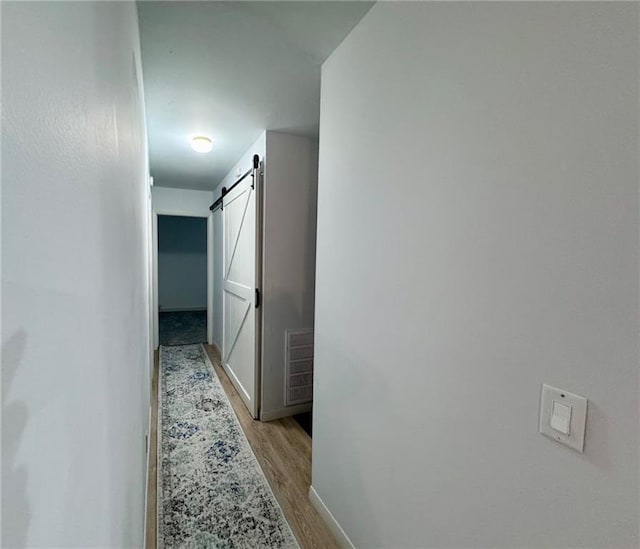 1012 Meadowbrook Rd E, Iola, KS 66749 - hall featuring a barn door and light wood-style floors