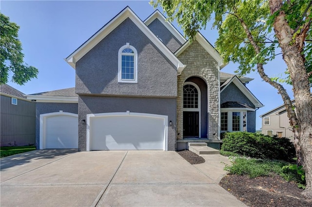 24108 W 67th Ter, Shawnee, KS 66226 - view of front of home with stucco siding, concrete driveway, stone siding, and a garage