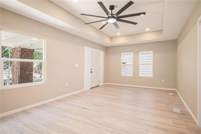 4036 Benton Blvd, Kansas City, MO 64130 - unfurnished room with a ceiling fan, light wood-type flooring, and a tray ceiling