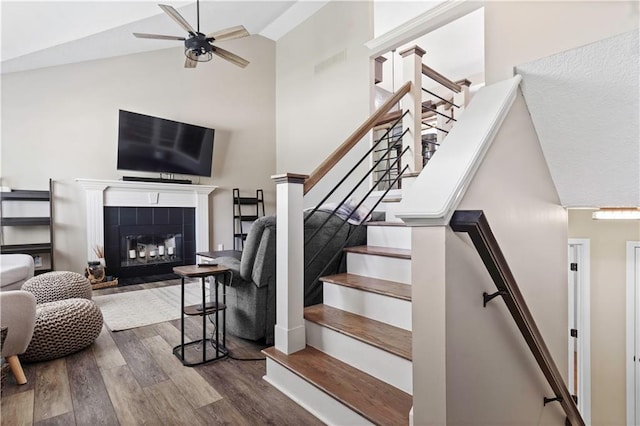 109 NW Whitlock Dr, Lees Summit, MO 64081 - stairway featuring wood finished floors, a ceiling fan, high vaulted ceiling, and a tile fireplace