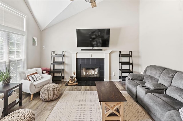 109 NW Whitlock Dr, Lees Summit, MO 64081 - living area with lofted ceiling, wood finished floors, a tiled fireplace, and a ceiling fan