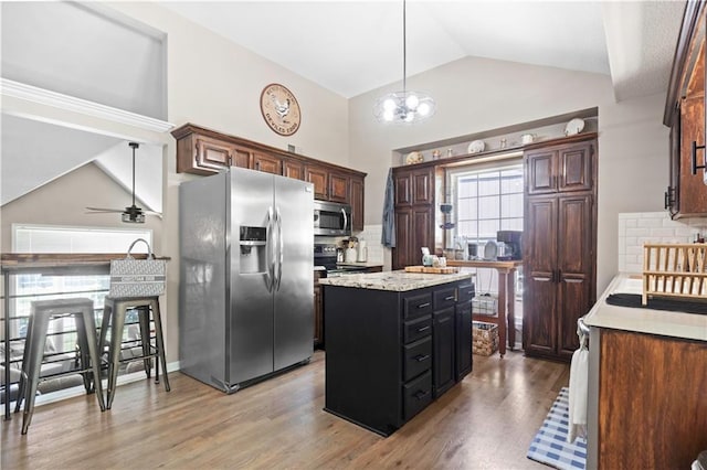 109 NW Whitlock Dr, Lees Summit, MO 64081 - kitchen with stainless steel appliances, tasteful backsplash, light wood-style floors, a kitchen island, and high vaulted ceiling