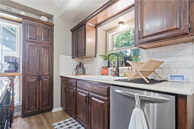 109 NW Whitlock Dr, Lees Summit, MO 64081 - kitchen featuring dishwasher, light countertops, light wood-style flooring, backsplash, and vaulted ceiling